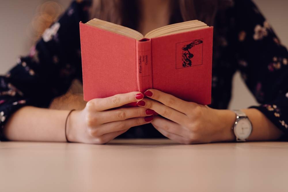 出版業界を印象付ける、本を読んでいる女性の画像です。